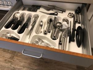 a drawer filled with utensils in a kitchen at Moderne Ferienwohnung am Yachthafen Bad Zwischenahn in Bad Zwischenahn