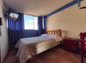 Un dormitorio con una cama y una ventana grande. en Hospedaje Manchego's, en Huancayo
