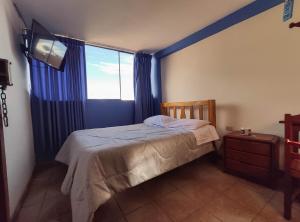 1 dormitorio con cama y ventana grande en Hospedaje Manchego's, en Huancayo