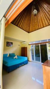 1 dormitorio con 1 cama azul en una habitación en Pandawa Beach Homestay en Uluwatu