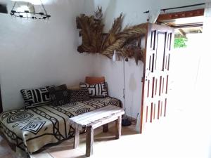 1 dormitorio con 1 cama y un banco junto a una puerta en Casa Tigot, en Valle Gran Rey