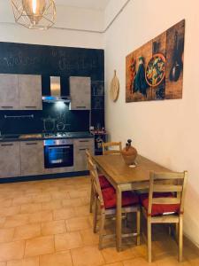 uma cozinha com uma mesa e cadeiras de madeira e uma cozinha com um fogão em Urban loft em Manciano