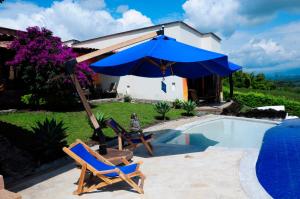 a pair of chairs and an umbrella next to a swimming pool at Casa Mar Verde in Armenia