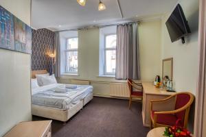 モスクワにあるMoscow Comfort Hotelのベッドとデスクが備わるホテルルームです。