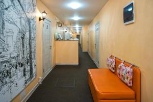 モスクワにあるMoscow Comfort Hotelの橙褐色のソファのある事務所廊下