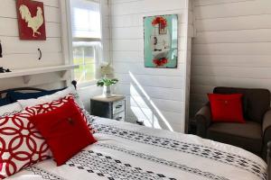 a bedroom with a bed with red pillows and a chair at Amazing Loft on Horse Ranch in Pilot Hill