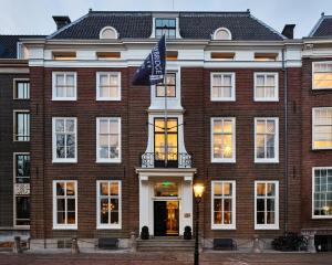 a brick building with a flag in front of it at Staybridge Suites The Hague - Parliament, an IHG Hotel in The Hague