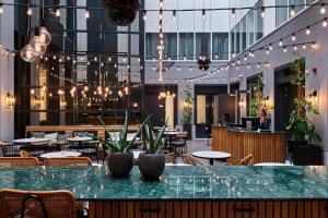 un restaurante con mesas, sillas y luces en Staybridge Suites The Hague - Parliament, an IHG Hotel, en La Haya