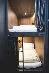 2 łóżka piętrowe w pokoju z drewnianymi ścianami w obiekcie Wink at McCallum Street w Singapurze