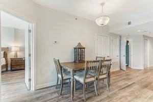 a dining room with a wooden table and chairs at Tidewater Condominiums in Orange Beach