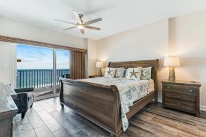 um quarto com uma cama e uma grande janela em Tidewater Condominiums em Orange Beach