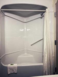 La salle de bains est pourvue d'une baignoire blanche avec rideau de douche. dans l'établissement Lone Star Inn, à Decatur