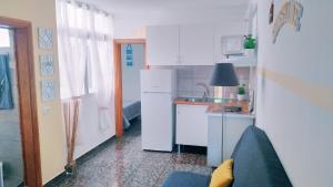 uma pequena cozinha com armários brancos e um lavatório em Sunshine & Burrero Beach Vacation em Playa del Burrero