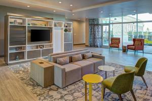 a living room with a couch and a tv at Holiday Inn Hotel & Suites - Houston West - Katy Mills, an IHG Hotel in Katy