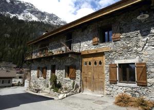 ein Steingebäude mit einer Holztür und einem Balkon in der Unterkunft Appartement Jorasses in Chamonix-Mont-Blanc