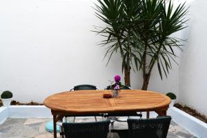 una mesa de madera con sillas y un jarrón de flores. en Alvor House Lagoon, en Alvor