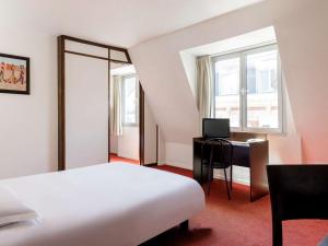 ein Hotelzimmer mit einem Bett, einem Schreibtisch und einem Fenster in der Unterkunft Aparthotel Adagio Access Lille Vauban in Lille
