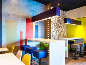a colorful restaurant with blue stools and a bar at Ibis Budget Mulhouse Centre Gare in Mulhouse