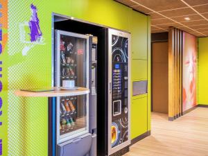- un réfrigérateur dans une chambre avec une table à côté dans l'établissement Ibis Budget Limoges Nord, à Limoges