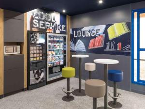 a drink station with stools and a refrigerator at ibis Budget Bobigny Pantin in Bobigny