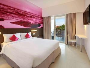 a bedroom with a large bed with a pink wall at Primera Hotel Seminyak in Seminyak +42 photos