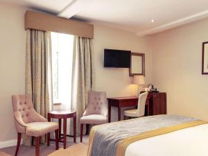 a hotel room with two beds and a television at Mercure Thame Lambert Hotel in Chinnor