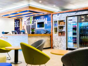 a restaurant with chairs and a bar with a refrigerator at ibis budget Copiapo in Copiapó