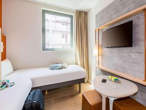 
a bedroom with a bed and a television at ibis budget Gent Centrum Dampoort in Ghent
