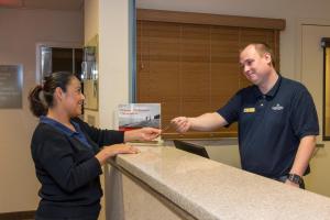 a man and a woman standing at a counter at Candlewood Suites Oak Harbor, an IHG Hotel in Oak Harbor