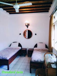 um quarto com duas camas e um espelho na parede em Bladok Hotel & Restaurant em Yogyakarta