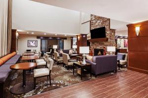 um átrio do hotel com lareira e mesas e cadeiras em Staybridge Suites Fort Worth Fossil Creek, an IHG Hotel em Fort Worth