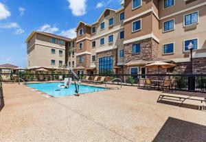 uma piscina em frente a um edifício de apartamentos em Staybridge Suites Fort Worth Fossil Creek, an IHG Hotel em Fort Worth