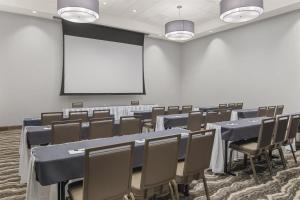 a conference room with tables and chairs and a white screen at Staybridge Suites - Florence Center by IHG in Florence +67 photos