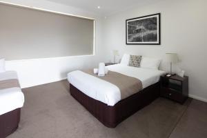 a bedroom with a large bed and a large window at Merivale Motel in Tumut