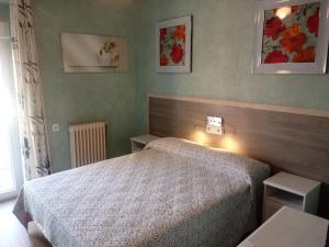 1 dormitorio con 1 cama y 2 mesas. en Hostal Welcome2 Alcázar en Alcázar de San Juan