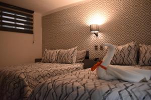 una habitación de hotel con una cama con un cisne en ella en El Suburbio - Morelos Sur en Morelia
