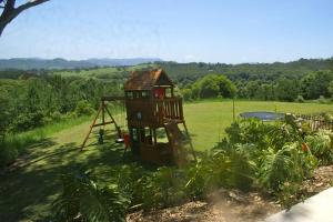 Byron Bay hinterland house - amazing sunset views! في Myocum: ملعب صغير في حقل مخصص للملاعب