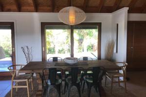 Byron Bay hinterland house - amazing sunset views! في Myocum: غرفة طعام مع طاولة وكراسي خشبية