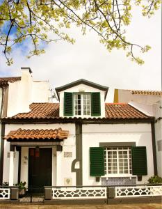 Casa blanca con persianas verdes en CASA INTI / INTI HOUSE FURNAS, en Furnas