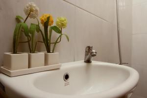 a bathroom sink with two vases with flowers on it at Bantal Guling Villa in Lembang