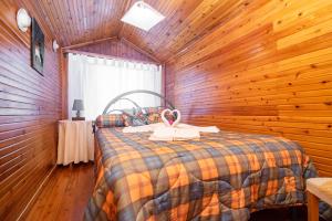 Un dormitorio con una cama en una pared de madera. en CASA INTI / INTI HOUSE FURNAS, en Furnas