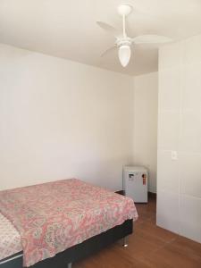 1 dormitorio con 1 cama y ventilador de techo en Quitinetes e Suites em Arraial, en Arraial do Cabo