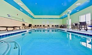una gran piscina con sillas y mesas en Holiday Inn Express & Suites - Perryville I-55, an IHG Hotel en Perryville