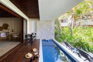 a house with a swimming pool and a living room at Tago Tulum by G Hotels in Tulum