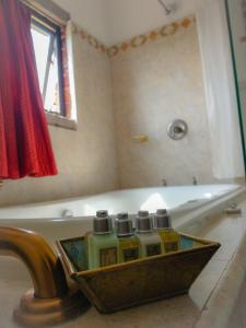 een badkamer met een bad met drie flessen zeep bij Las Calandrias in Atlixco