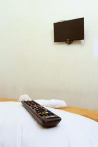 a remote control sitting on top of a bed at Unique Guesthouse in Bandung