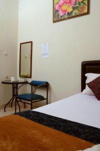 a bedroom with a bed and a table and a mirror at Unique Guesthouse in Bandung