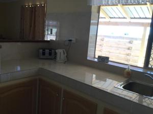 encimera de cocina con fregadero y ventana en Caretakers Cottage Budget Accommodation, en Denham