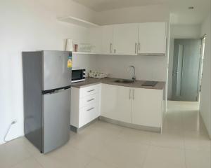 a kitchen with white cabinets and a stainless steel refrigerator at Grandblue condominium Room 606 in Mae Pim