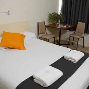 a bedroom with a bed with two towels on it at Shamrock Hotel Motel Temora in Temora